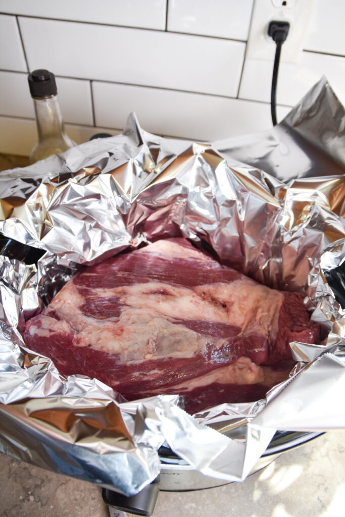 Beef Brisket in a large piece of foil in a crockpot